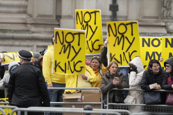 FILE -Protesters hold placards with the message "Not my king" before Britain's King Charles III arrives to attend the annual Commonwealth Day service at Westminster Abbey in London, Monday, March 13, 2023.  (AP Photo/Frank Augstein, File)